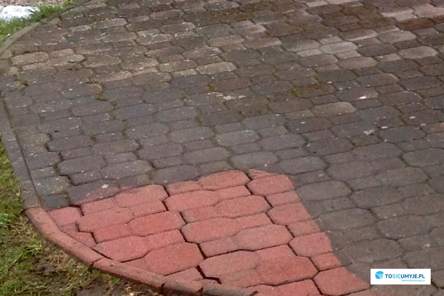 Fragment okrągłego podjazdu z kostki brukowej, widoczna różnica w kolorze między czystą, czerwoną częścią a brudną, szarą częścią, po lewej stronie widoczna trawa.