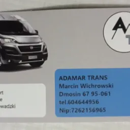 Wizyt&oacute;wka firmy transportowej Adamar Trans z ilustracją szarego busa, logo z literami A i T, adresem i numerem telefonu.