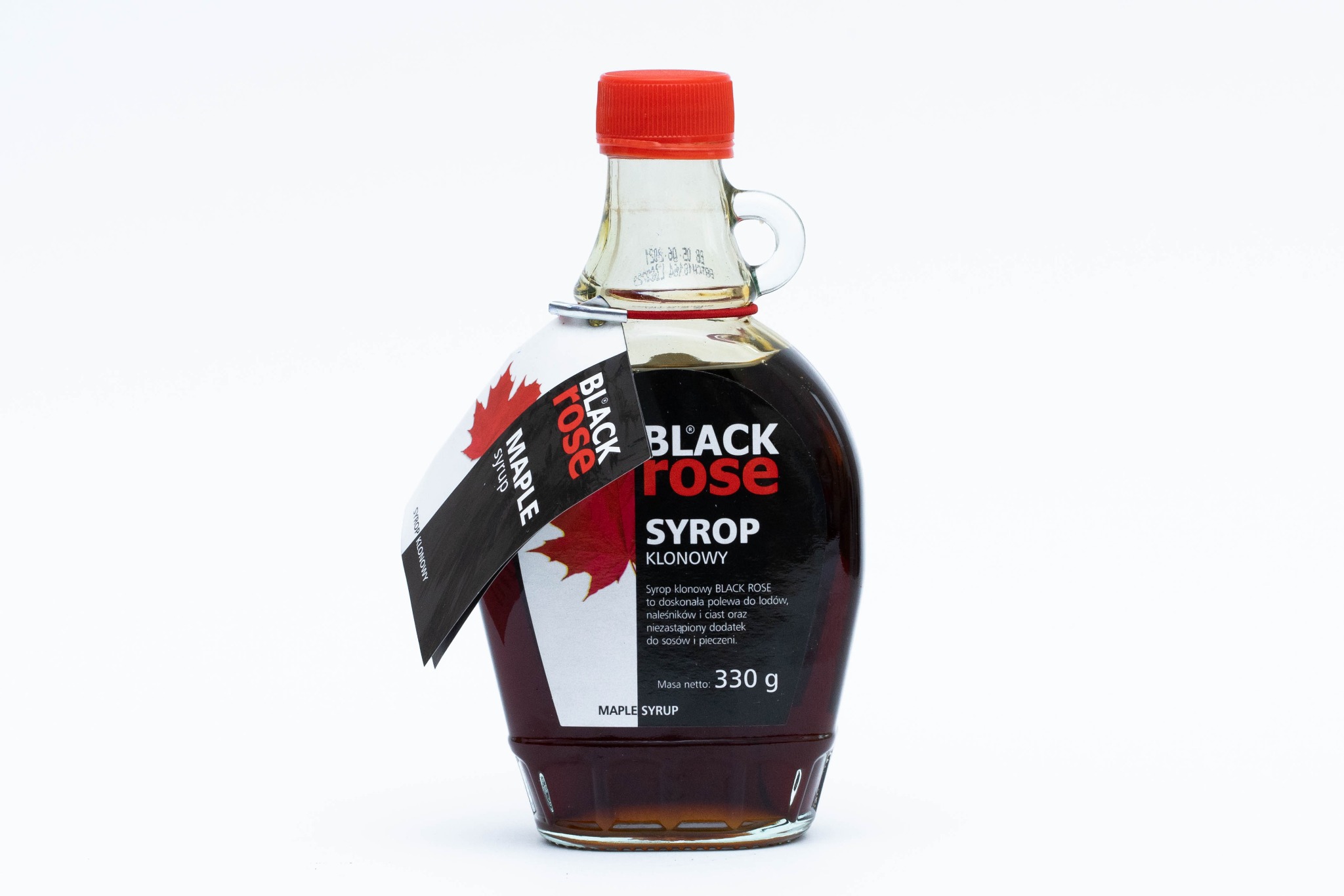Butelka syropu klonowego Black Rose z czerwoną nakrętką i etykietą z liściem klonu na białym tle.