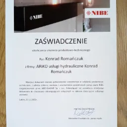 Skan zaświadczenia o ukończeniu szkolenia produktowo-technicznego z zakresu pomp ciepła NIBE, wystawionego dla Pana Konrada Romańczuka z firmy ARIKO usługi hydrauliczne Konrad Romańczuk, z podpisem...