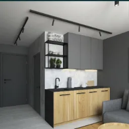 Nowoczesna aranżacja małej kuchni z drewnianymi szafkami dolnymi, szarymi szafkami górnymi, czarnym blatem i armaturą, oświetleniem szynowym oraz minimalistycznym plakatem na ścianie w szarym kolorze.