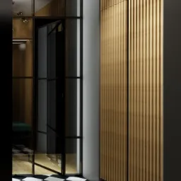 Nowoczesny przedpokój z czarno-białą szachownicą na podłodze, ścianą z drewnianych paneli pionowych i szklanymi drzwiami z czarnymi ramami, oświetlony lampą sufitową z kulistymi kloszami.