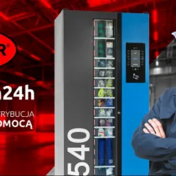 Pracownik w niebieskim kasku stoi obok automatu vendingowego z produktami BHP, widoczne logo firmy Bogmar i napis Magazyn24h.