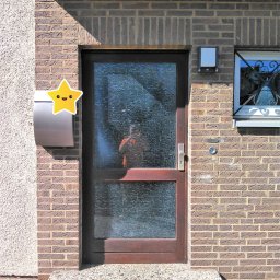 ROMPIS Roman Piszczek - Wejście do domu w Gliwicach z brązowymi drzwiami szklanymi o wzorzystej fakturze, skrzynka pocztowa ze śmieszną naklejką gwiazdki i małe okno z ozdobną kratą.