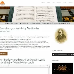 Strona internetowa Międzynarodowego Festiwalu Muzyki Chóralnej im. Ignaza Reimanna w Wambierzycach, z widocznymi nutami na pulpitach dla orkiestry w tle.