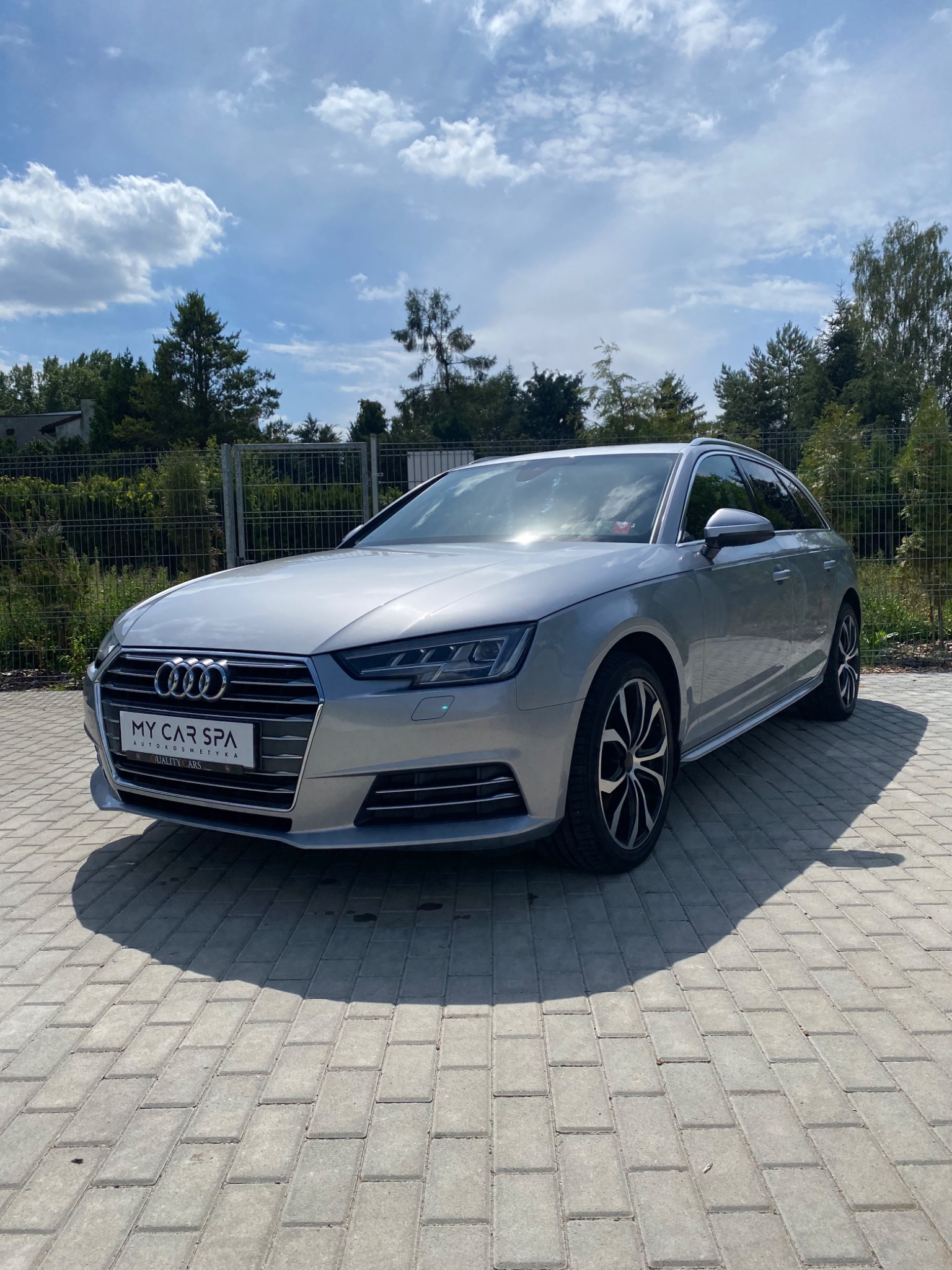 Srebrne Audi A4 Avant po zabiegach auto detailingu, z widocznym logo 'My Car Spa' na tablicy rejestracyjnej, zaparkowane na brukowanym podjeździe w słoneczny dzień.