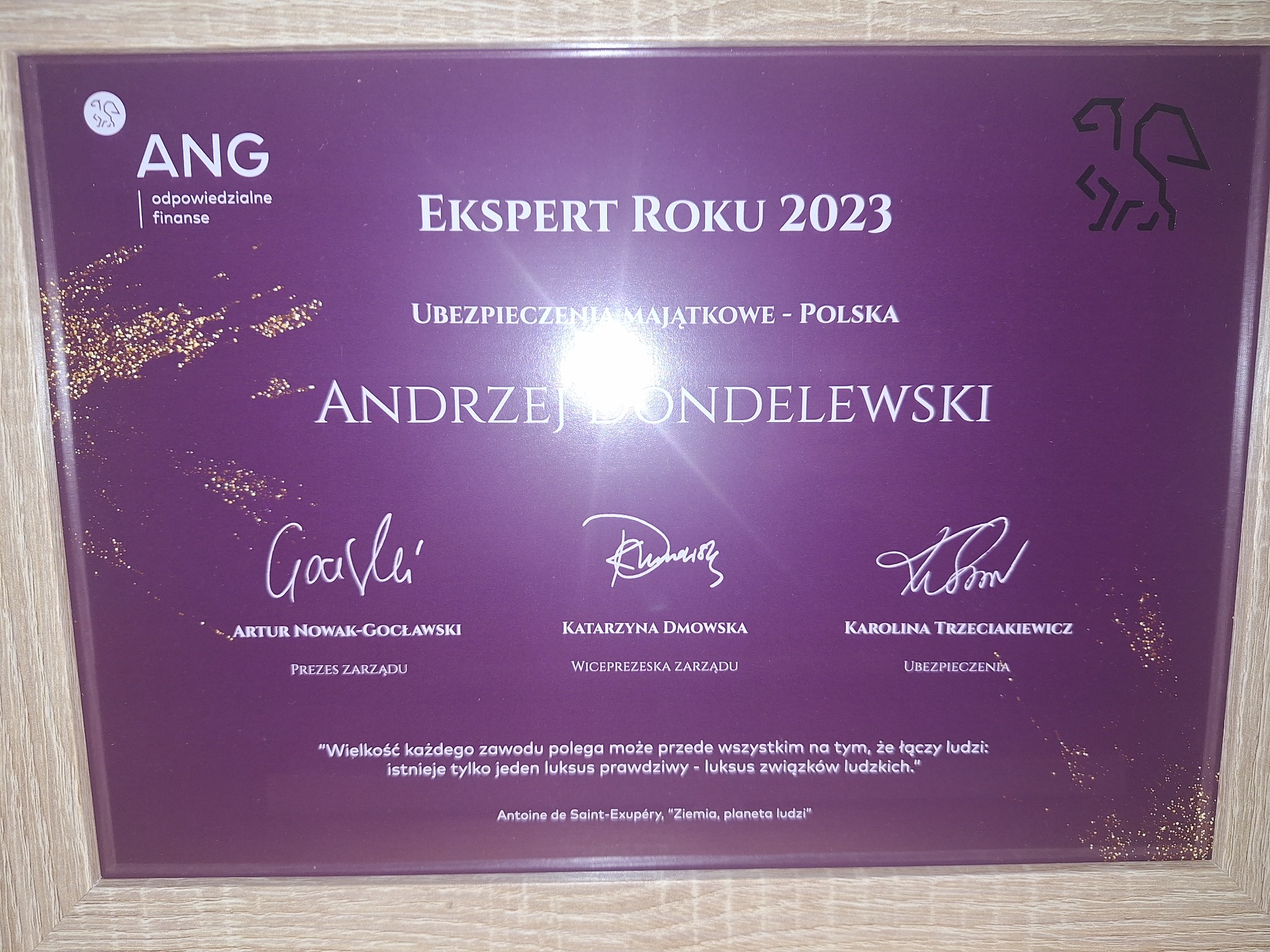 Dyplom 'Ekspert Roku 2023' dla Andrzeja Dondelewskiego w dziedzinie ubezpieczeń majątkowych, z podpisami Artura Nowak-Gocławskiego, Katarzyny Dmowskiej i Karoliny Trzeciakiewicz, w ramce o fakturze...