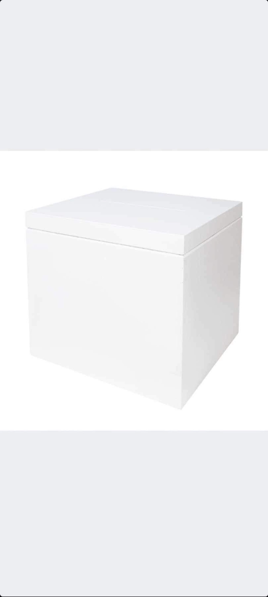 Prosty, biały, kwadratowy pojemnik z pokrywką, wykonany z gładkiego materiału, sfotografowany z lekkiego kąta, z widocznymi subtelnymi cieniami.