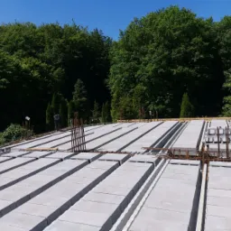 Wieniec stropowy Teriva w trakcie budowy, widoczne zbrojenie i pustaki stropowe, w tle zieleń drzew