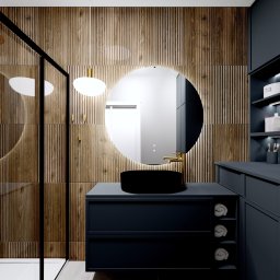 Cozy Studio - Nowoczesna łazienka z drewnianą ścianą, okrągłym lustrem i czarną umywalką na granatowej szafce. W tle kabina prysznicowa i półki z akcesoriami.