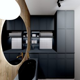 Cozy Studio - Nowoczesna łazienka w odcieniach szarości i drewna: owalne lustro z podświetleniem, czarna umywalka nablatowa i szafki z półkami na ręczniki.