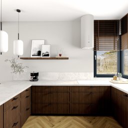 Cozy Studio - Nowoczesna kuchnia z drewnianymi szafkami, białym blatem i dużym oknem z widokiem na las. Minimalistyczne lampy wiszące i parkiet w jodełkę dodają elegancji.