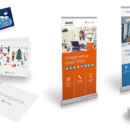 Agencja Reklamowa Motive Marek Pisarik - Zestaw materiałów reklamowych Microsoft: wizytówki, kartki świąteczne z motywem psa, roll-upy z hasłami reklamowymi Office i Windows 10 Pro, na białym tle.