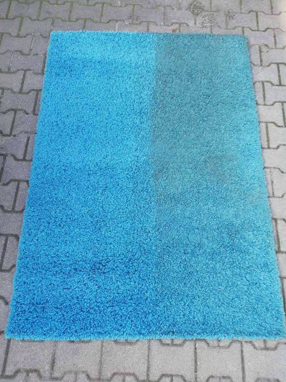 Turkusowy dywan shaggy, po lewej stronie świeżo wyczyszczony, po prawej widoczna różnica przed czyszczeniem, ułożony na szarej kostce brukowej.
