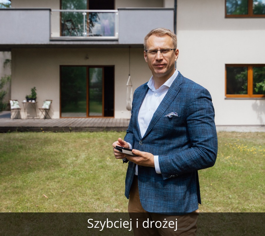 Mężczyzna w okularach i niebieskiej marynarce w kratę, stojący na tle domu z ogrodem, trzymający w rękach smartfon.