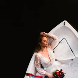 Panna młoda w koronkowej sukni, z bukietem w rękach, relaksuje się w białej łodzi na tle ciemnej wody, w okularach w cienkiej oprawce.