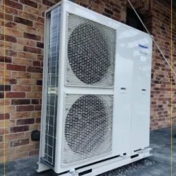 Zewnętrzna jednostka klimatyzacyjna Panasonic Inverter o mocy 9 kW, zamontowana przy ceglanej ścianie budynku w Straszynie.