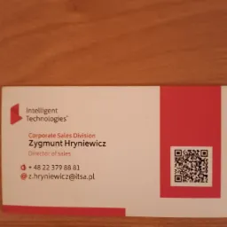 Wizytówka firmy Intelligent Technologies z danymi kontaktowymi Zygmunta Hryniewicza, Dyrektora Sprzedaży, oraz kodem QR.