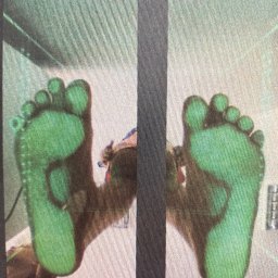 Fizjo Kraina. Rehabilitacja dzieci i niemowląt Monika Kalińska - Stopy pacjenta poddane badaniu na platformie diagnostycznej, z zielonymi obszarami wskazującymi na punkty nacisku.