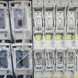 Szereg bezpieczników topikowych AAMATOR ARS 00 PRO zamontowanych w rozdzielnicy, widoczne parametry elektryczne i oznaczenia IP30.