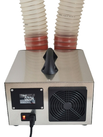 Generator ozonu w metalowej obudowie z dwoma elastycznymi wężami, włączony, z wyświetlaczem wskazującym 'Ideal OZON'.