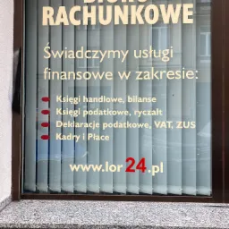 Szyld Biura Rachunkowego z wykazem świadczonych usług finansowych, w tym księgi handlowe, podatkowe, deklaracje VAT, ZUS oraz kadry i płace, widoczny przez okno z żaluzjami.