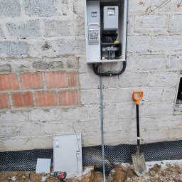 Wyniesienie licznika. Powieszenie skrzynki dostosowanej do zamontowania licznika energii elektrycznej. Dodatkowo wykonanie uziemienia pionowego za pomocą szpilek. 