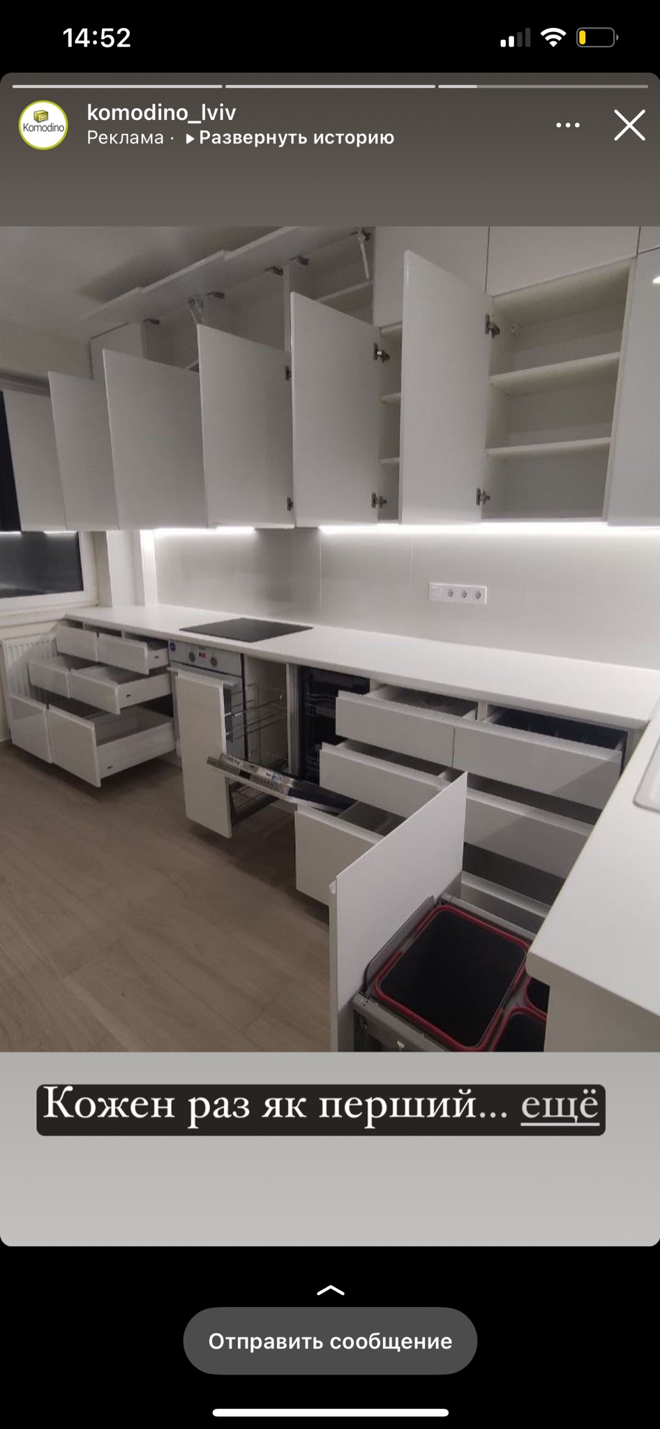 Nowoczesna, biała kuchnia z otwartymi szafkami górnymi na podnośnikach, wysuwanymi szufladami i systemem sortowania odpadów z czerwonymi akcentami.