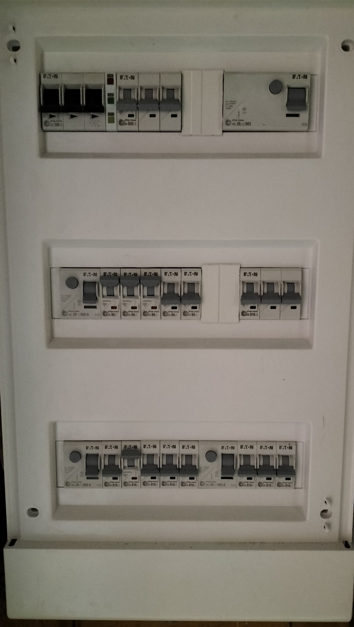 Rozdzielnica elektryczna Eaton z zainstalowanymi bezpiecznikami, widok z bliska na białą obudowę z trzema rzędami wyłączników.