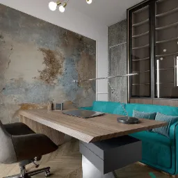 Nowoczesne biuro domowe z drewnianym biurkiem o asymetrycznym blacie, szarą szafką, chromowaną lampką, turkusową sofą i krzesłem na kółkach, na tle ściany z efektem betonu i dekoracyjnej ściany...