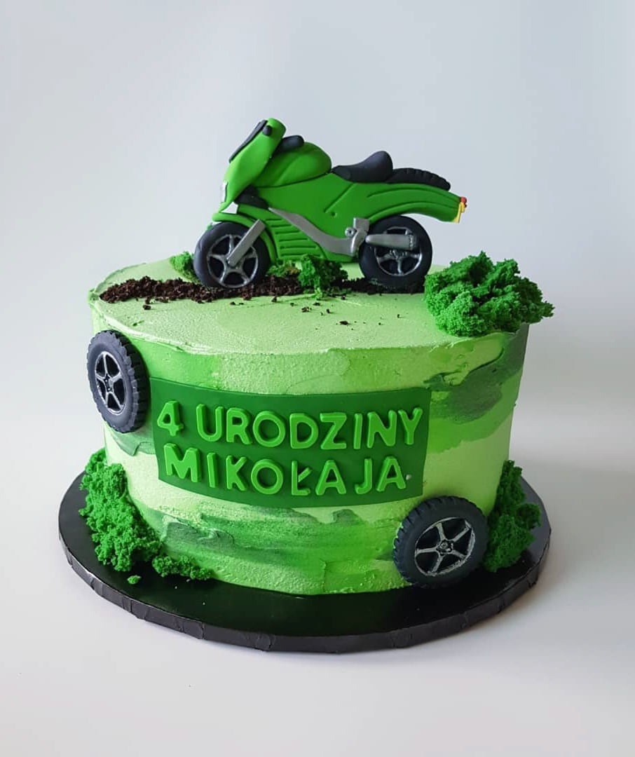 Tort urodzinowy dla 4-latka w zielonej kolorystyce z motocyklem i kołami samochodowymi jako dekoracją.