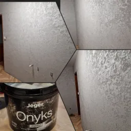 Ściana z dekoracyjną, srebrną strukturą 'Onyks' marki Jeger, widoczna w zbliżeniu z fragmentami innych ścian i wiadrem z farbą w dolnym lewym rogu.