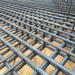 Siatka zbrojeniowa z prętów żebrowanych ułożona na szalunku, widok z góry pod kątem.