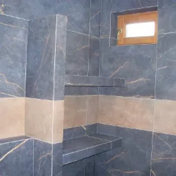 Wykończona kabina prysznicowa z ciemnymi płytkami imitującymi marmur ze złotymi żyłami, z drewnianym oknem i półkami wewnątrz.