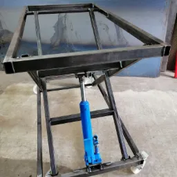 Stół roboczy z metalowych profili, wyposażony w podnośnik hydrauliczny i kółka, surowy metal, widoczne spawy.