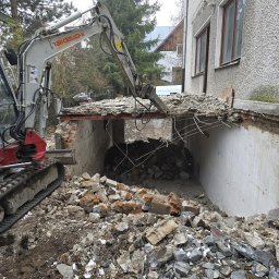 ROLLERRENT EWELINA BOSAKIEWICZ - Mini koparka Takeuchi z hydraulicznym młotem kruszy betonową konstrukcję budynku, gruz i ziemia na pierwszym planie.