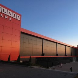 Yevhen Havrilov - Nowoczesny budynek biurowy Plaza Park z dużą fasadą szklaną i czerwonymi panelami, widok z zewnątrz o zmierzchu.