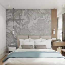 Jasna sypialnia z łóżkiem, tapetą w kwiaty, biurkiem i krzesłem, oświetlona lampami wiszącymi i światłem dziennym, z widocznym detalem gniazdka elektrycznego nad stolikiem nocnym.