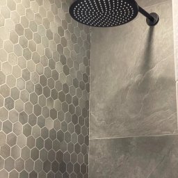 KOCHACZEWSKA DESIGN ANNA KOCHACZEWSKA-LIS - Nowoczesna kabina prysznicowa z szarymi, heksagonalnymi płytkami na ścianie i deszczownicą w kolorze czarnym.