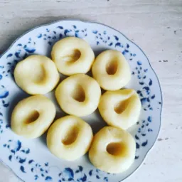 Kluski śląskie na talerzu z niebieskim wzorem kwiatowym, przygotowane w Iławie, gotowe do podania.