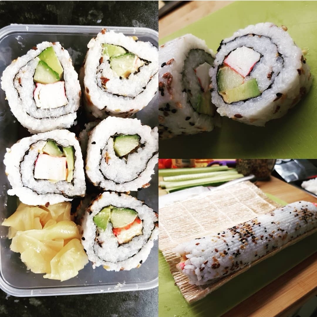 Sushi kalifornijskie z awokado i paluszkiem krabowym: gotowe porcje w plastikowym pojemniku obok rolki na bambusowej macie, z bliska.