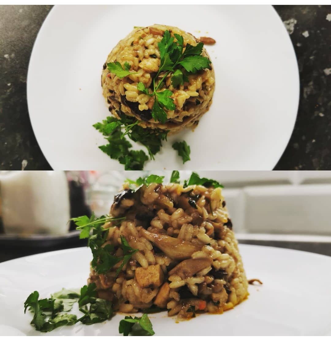 Dwie porcje risotto z grzybami, uformowane w kształt kopca i udekorowane świeżą natką pietruszki, podane na białych talerzach z różnym tłem.