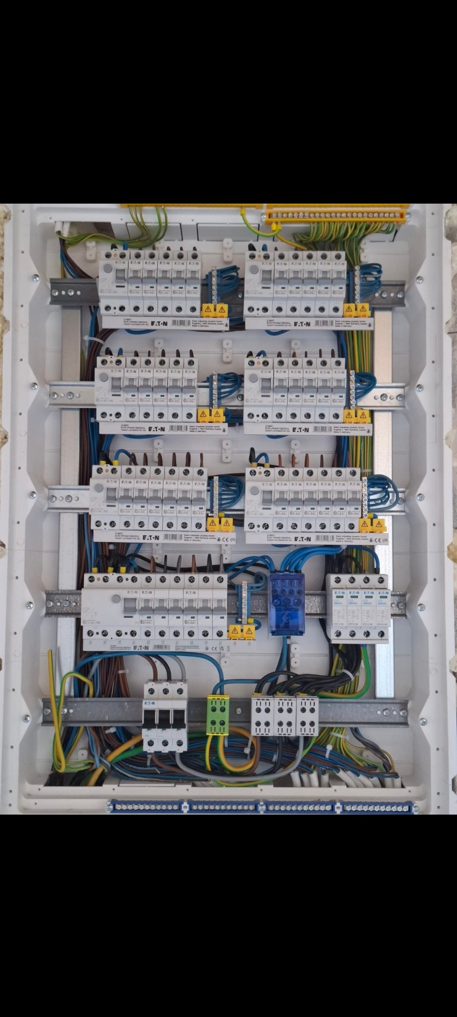 Rozdzielnia elektryczna z bezpiecznikami EATON, okablowaniem i listwami zaciskowymi, widok z góry. Gotowa instalacja w białej obudowie.
