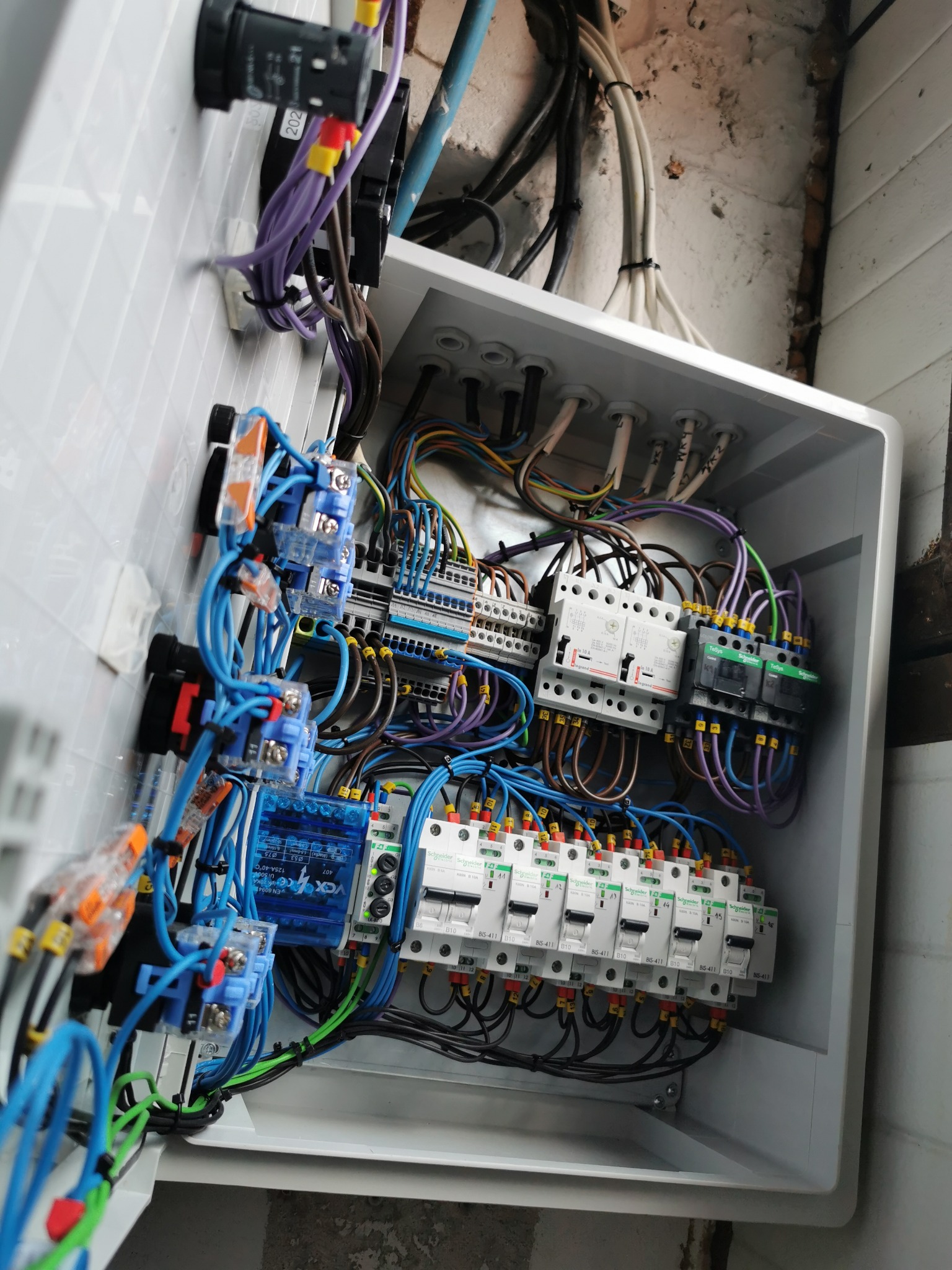 Wnętrze tablicy sterowania oświetleniem i podnośnikiem na warsztacie.