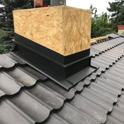 PlUAroof.pl - Obróbka komina z blachy i płyty OSB na dachu pokrytym metalową dachówką modułową w kolorze grafitowym.