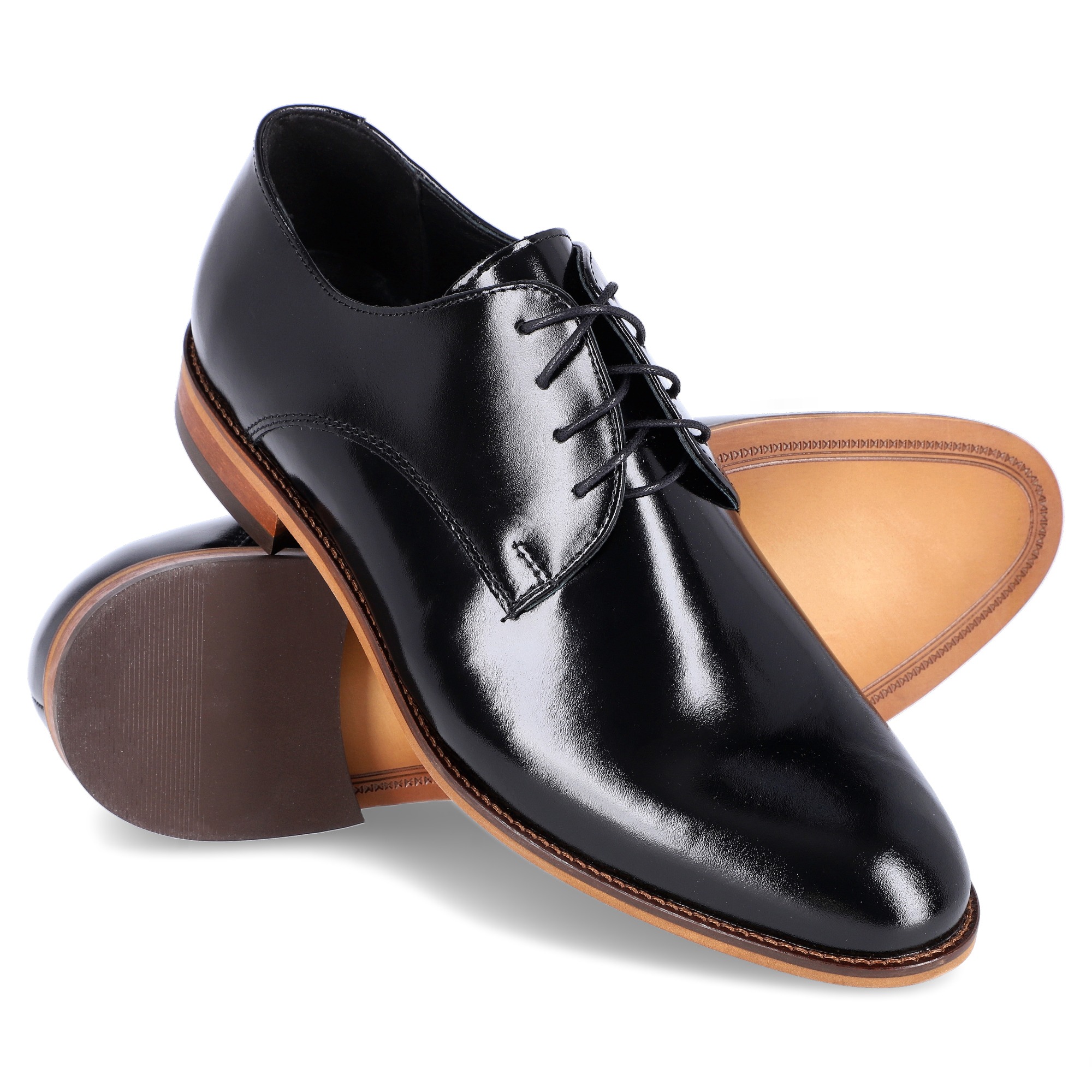 Para eleganckich, czarnych, skórzanych oksfordów, ułożonych jeden na drugim, prezentujących połyskliwą powierzchnię i detale podeszwy.
