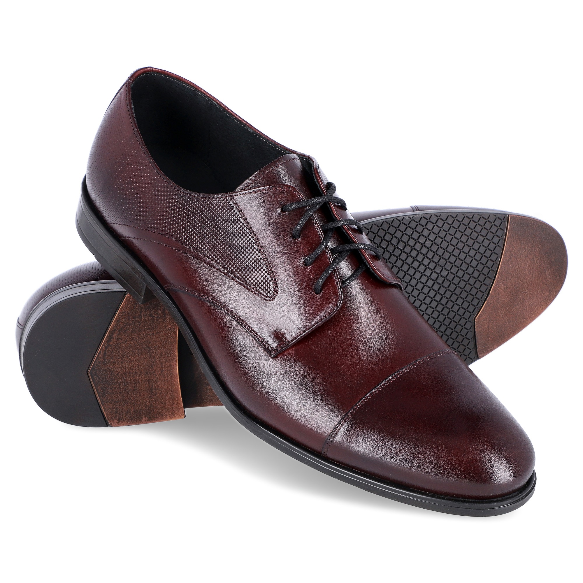 Para eleganckich, bordowych, skórzanych oksfordów z czarnymi sznurówkami, ustawionych na białym tle, prezentujących podeszwę z antypoślizgowym wzorem.