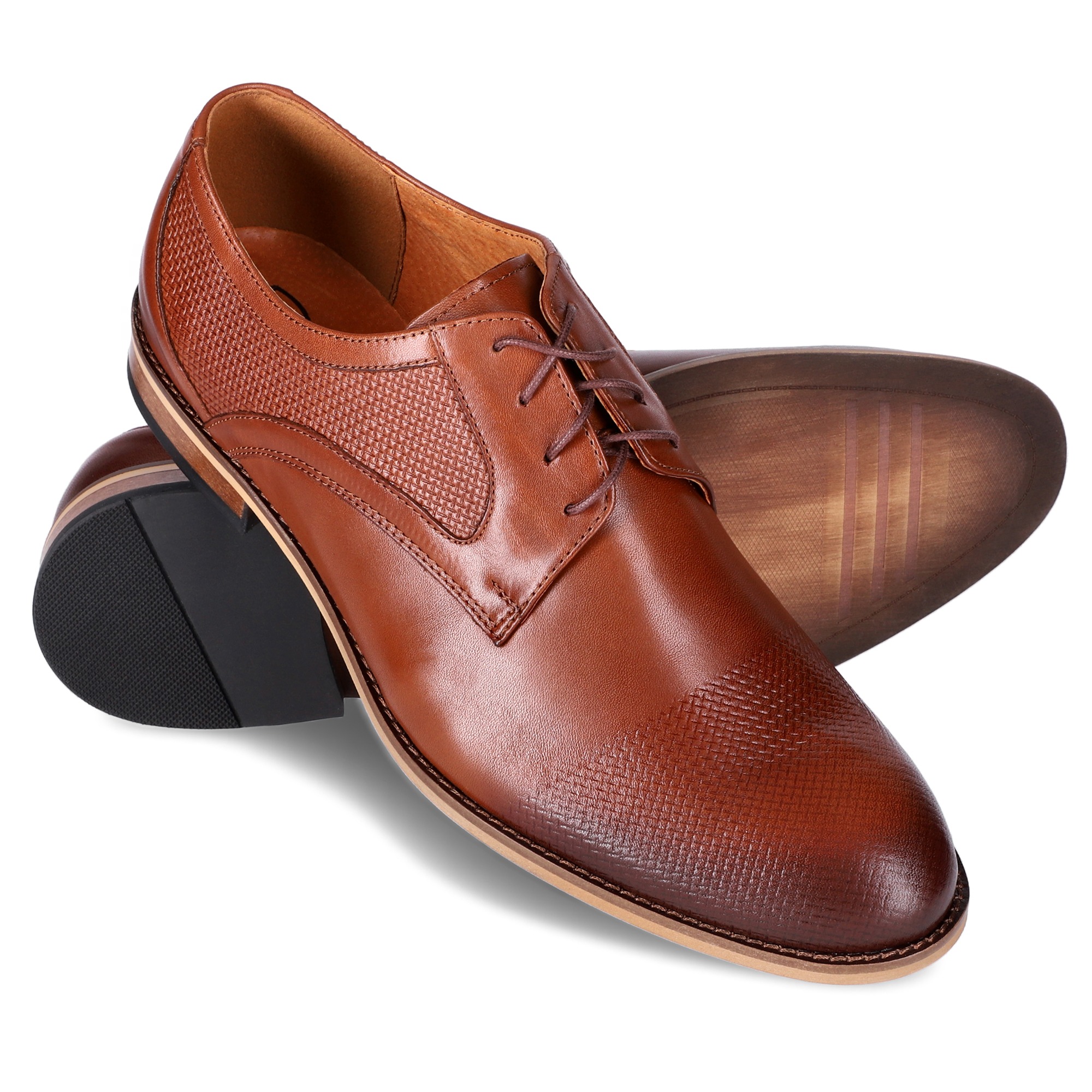 Brązowe, skórzane buty męskie z dekoracyjnym wzorem w Częstochowie, prezentowane z podeszwą skierowaną do góry, ukazującą jej strukturę.