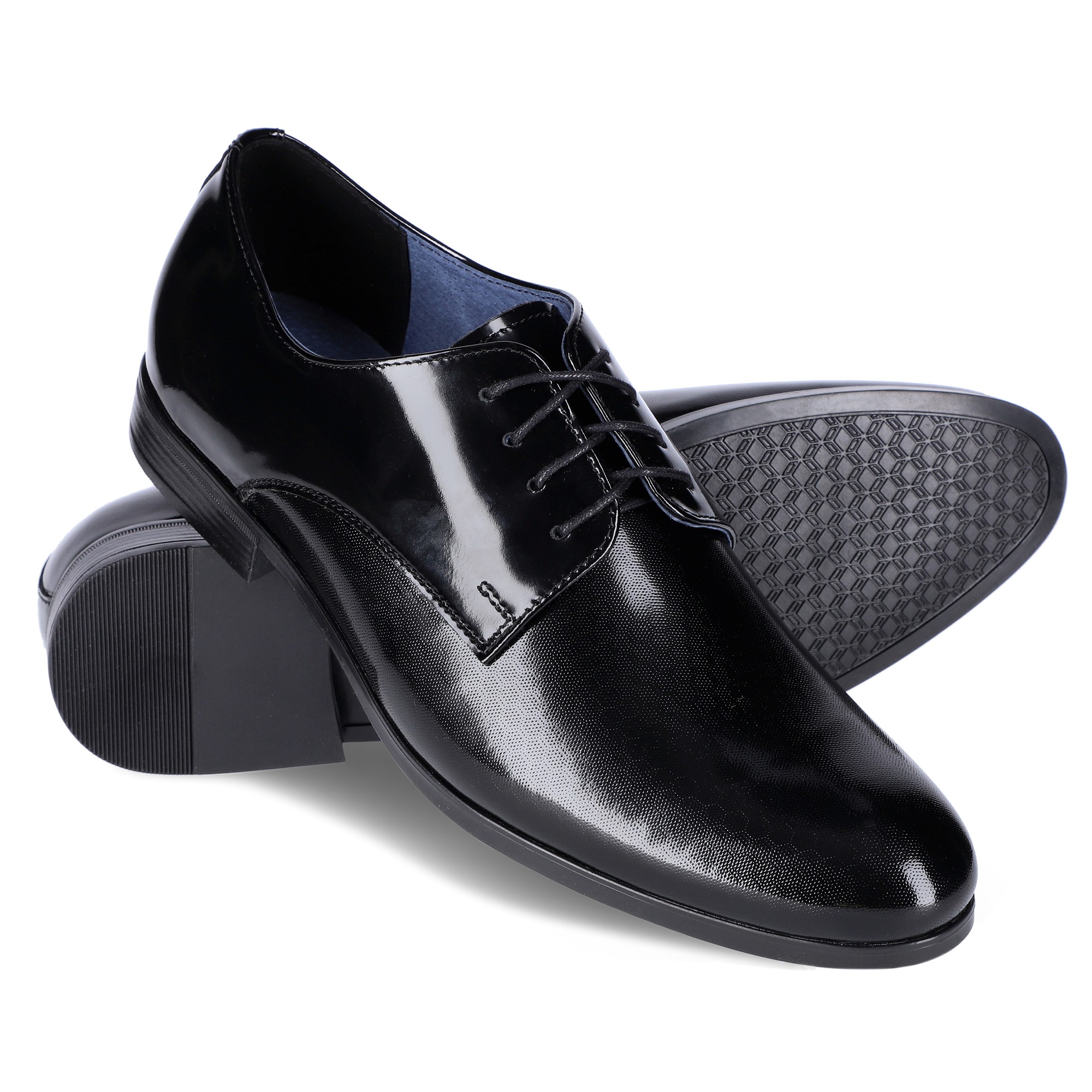 Para czarnych, lakierowanych, skórzanych oksfordów męskich, z delikatną fakturą, ułożona na białym tle, z widoczną podeszwą jednego buta.