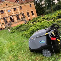 Palmeta - Profesjonalna myjka ciśnieniowa Karcher na trawniku przed okazałą, dwupiętrową willą z elementami dekoracyjnymi i zadbanym ogrodem.